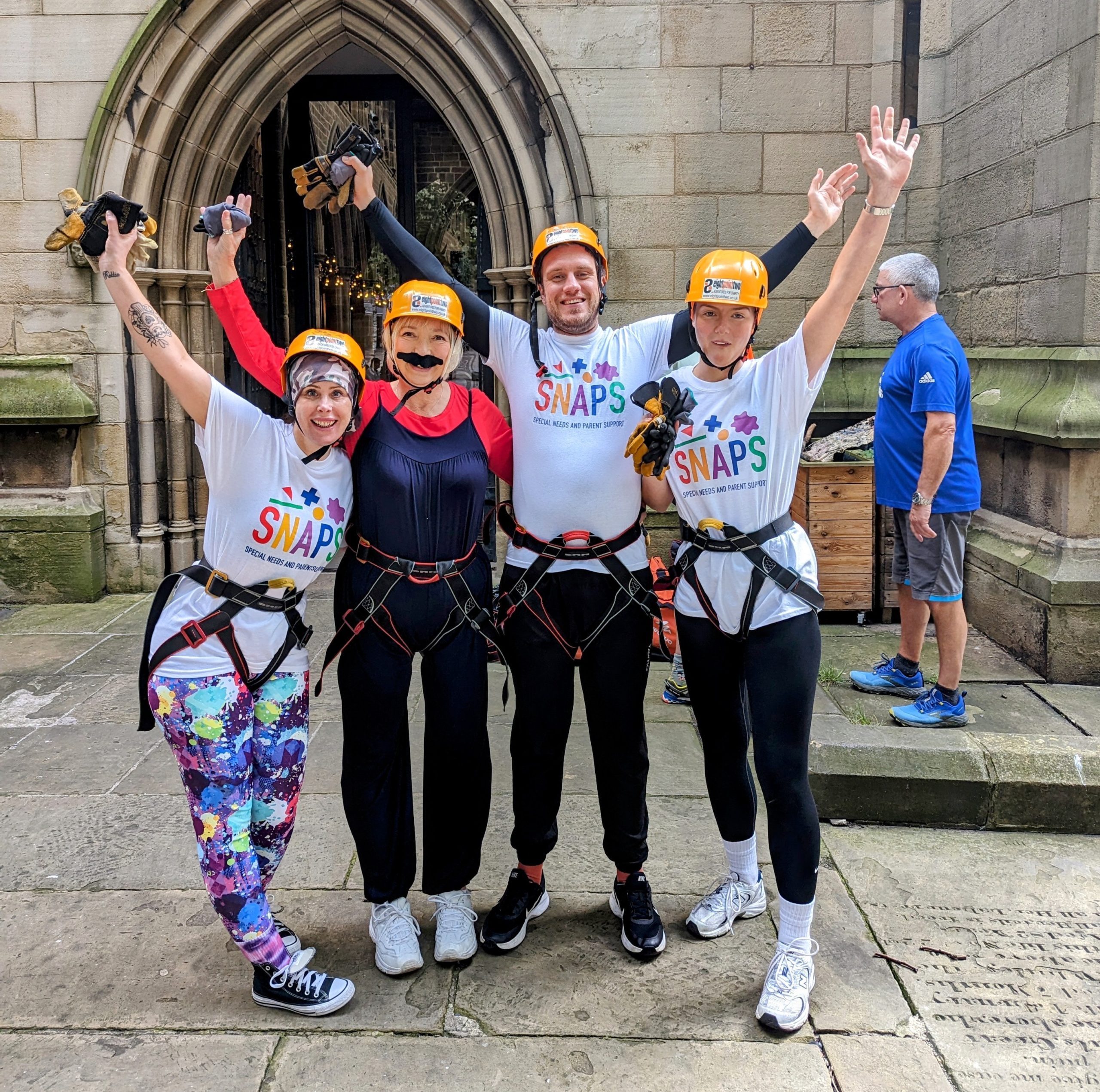 Group of SNAPS fundraIsers wearing harnesses for abseiling